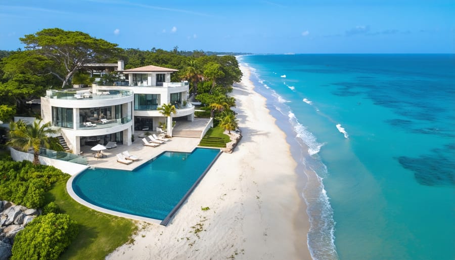 Stunning aerial view of modern luxury beachfront estate with infinity pool and landscaped grounds
