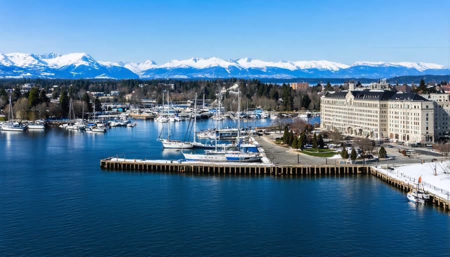 Scenic view of Victoria BC's waterfront showing the Parliament Buildings, boats, and mountains